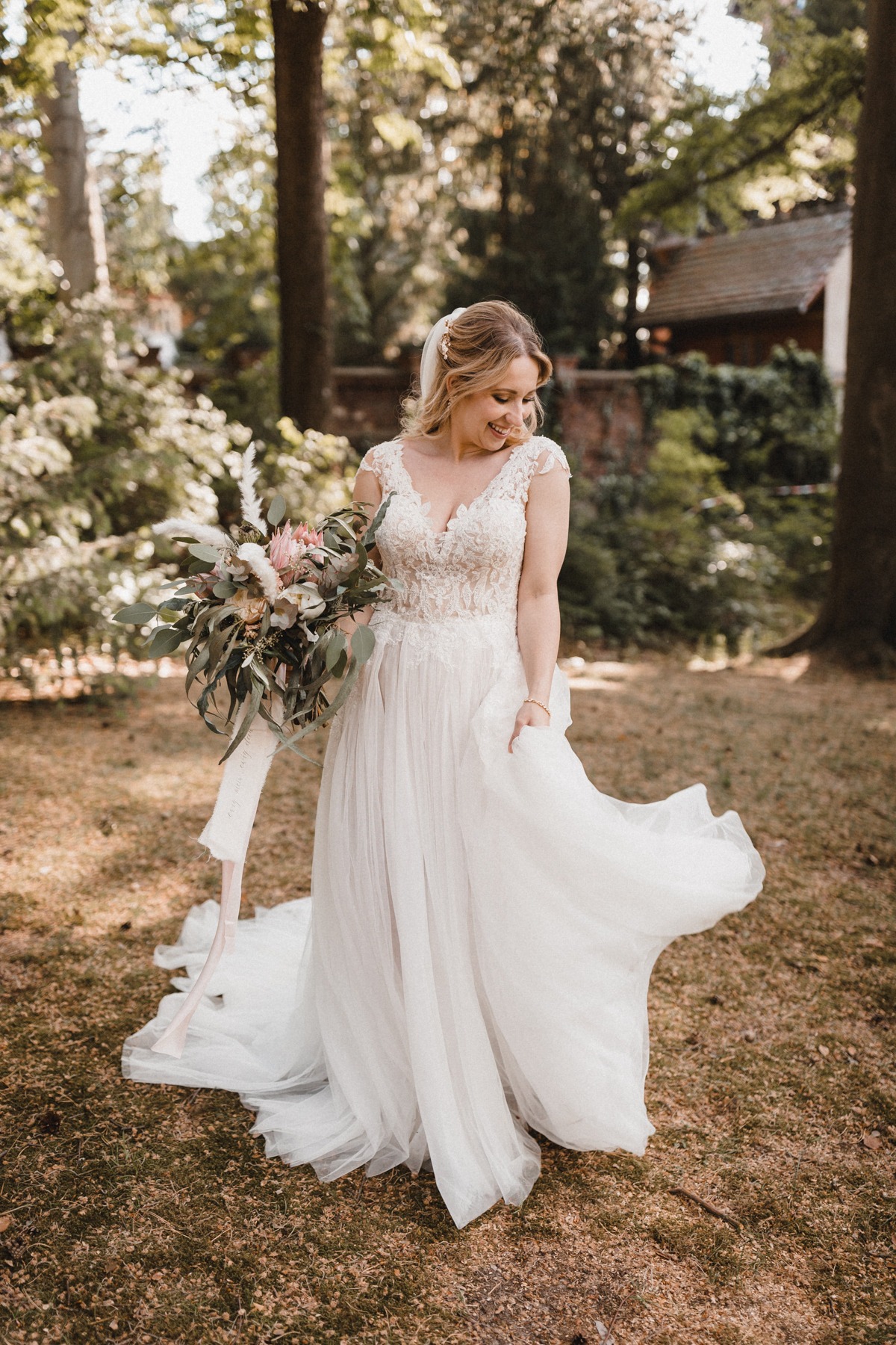 Glückliche Braut in A-Linien Brautkleid mit einem Traum aus Tüll und einer langen Schleppe