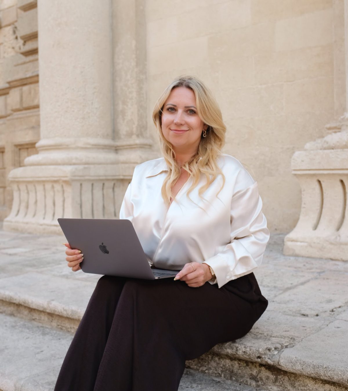 Authentische Businessfrau mit Laptop vor historischen Gebäuden in Berlin.