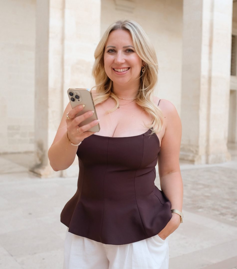 Attraktive Frau mit Smartphone vor historischen Gebäuden in Berlin.